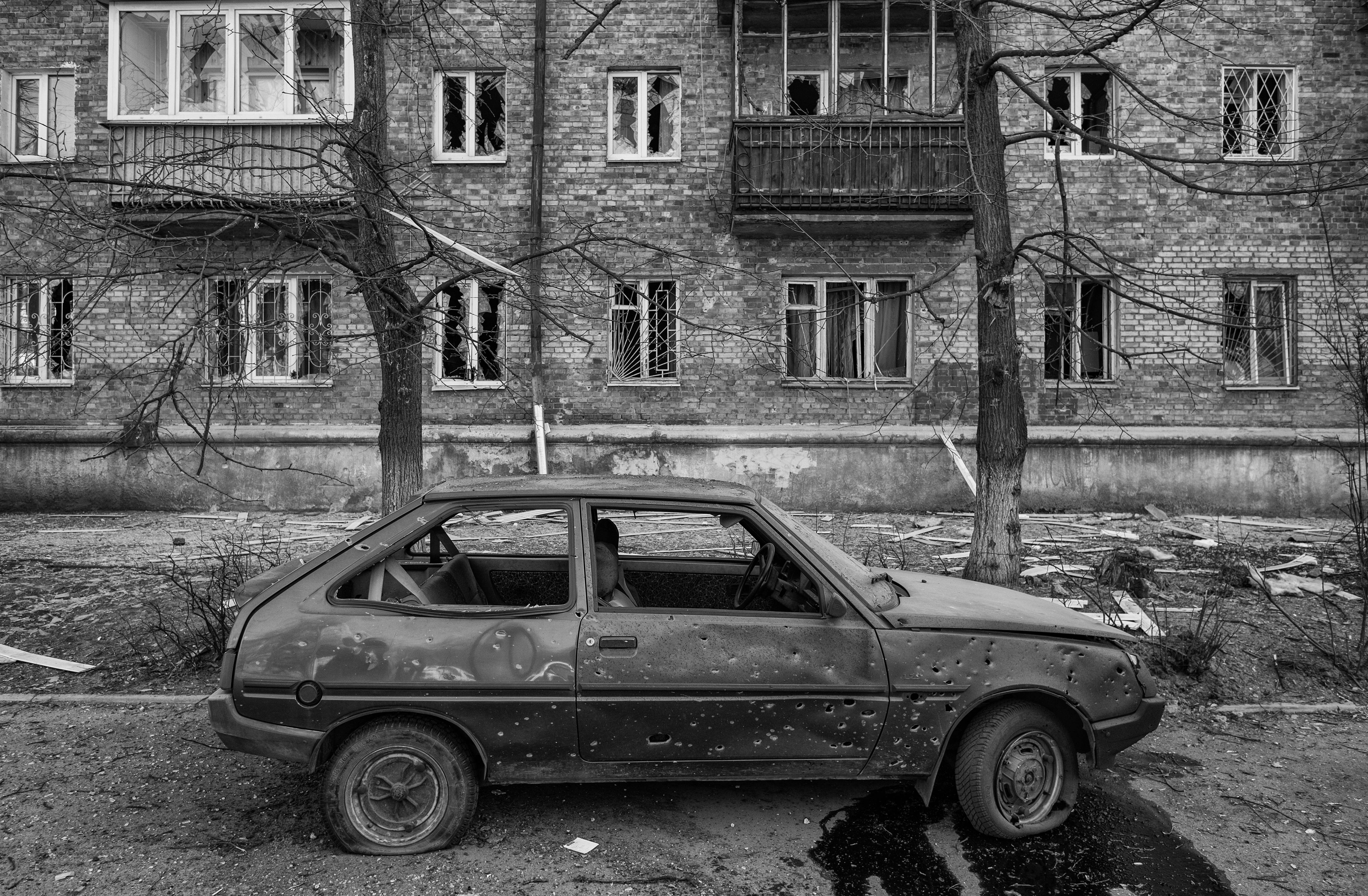 A vehicle in Kyiv is damaged in a residential area after the area was targeted by Russian rockets.