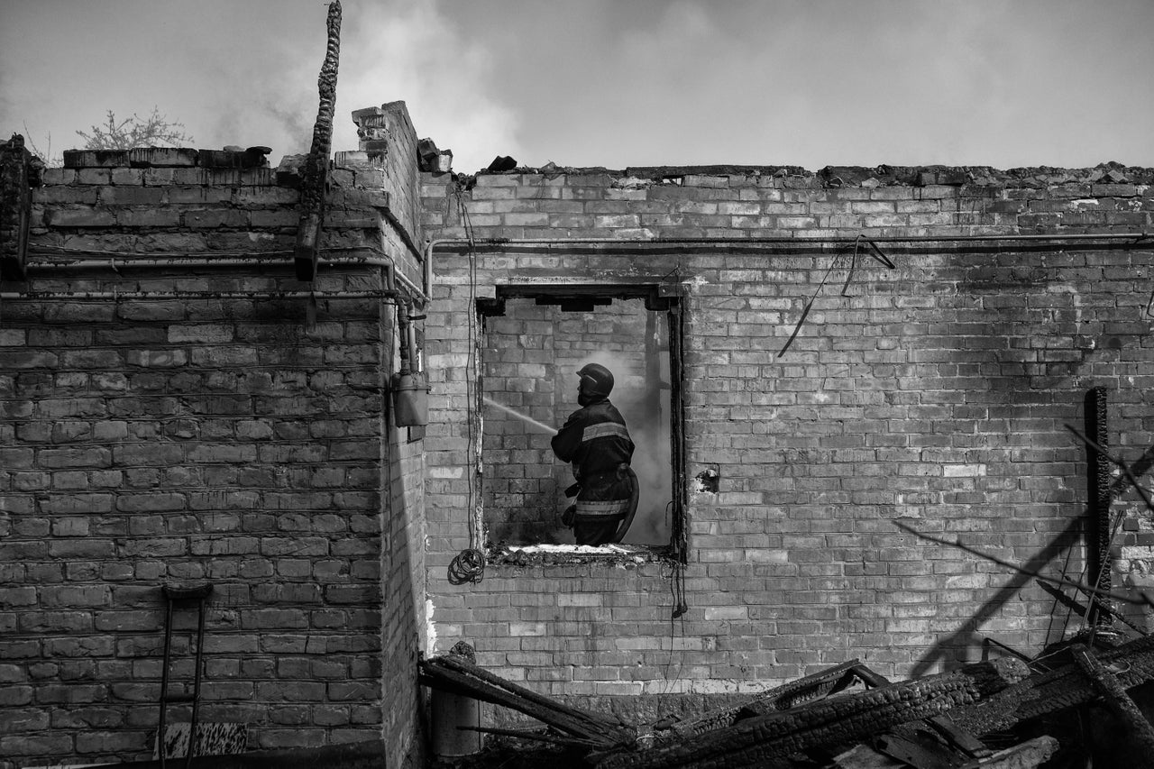 A firefighter puts out a fire in a home that was hit by a Russian rocket in Kyiv.