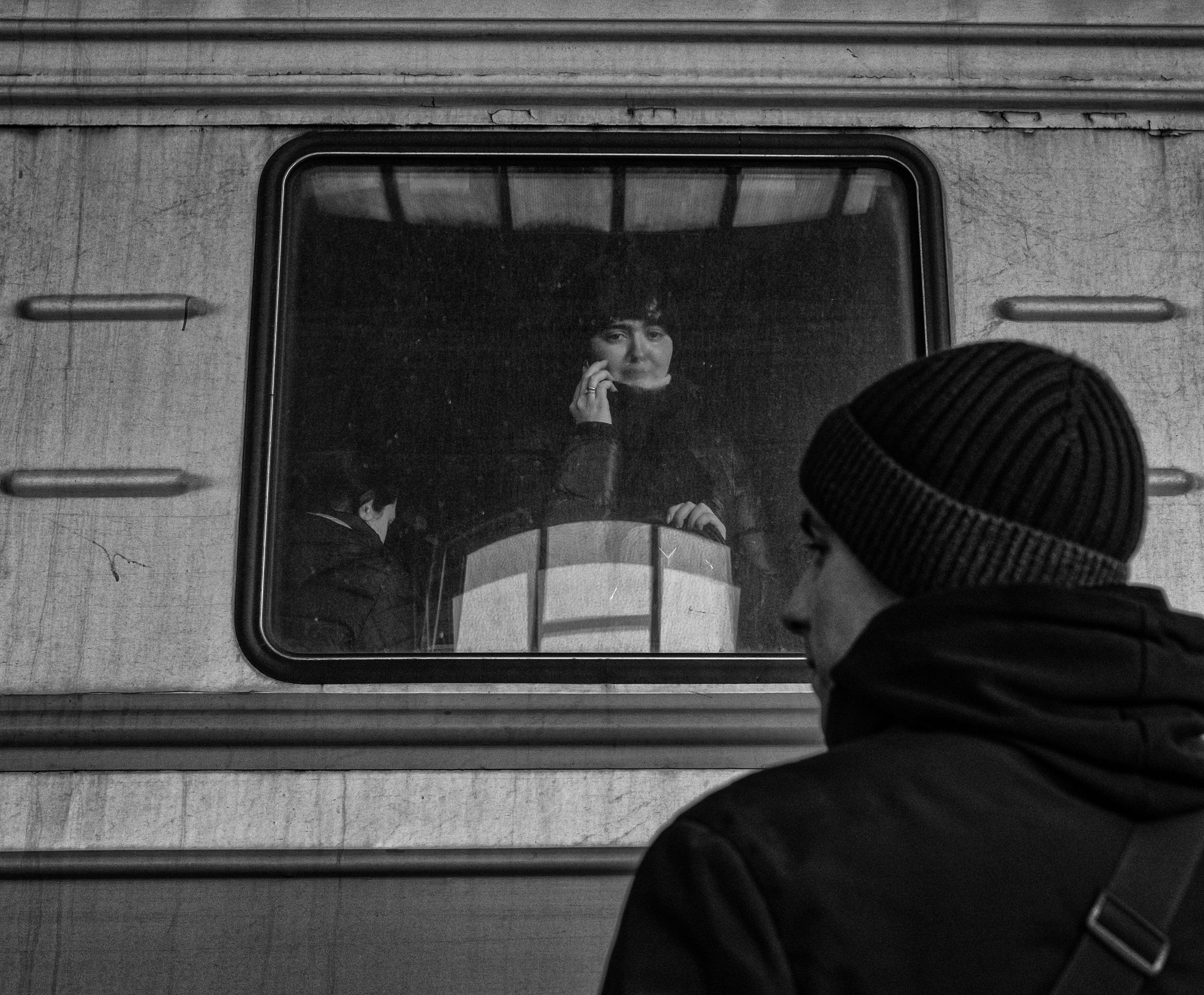 A young couple talk to each other over their cell phones at Lviv-Holovnyi railway station where thousands of Ukrainian refugees pass through daily for trains bound for Poland, Romania and other neighboring countries to escape the war as the Russian invasion of Ukraine continues. Men age 18-60 have been banned from leaving Ukraine.