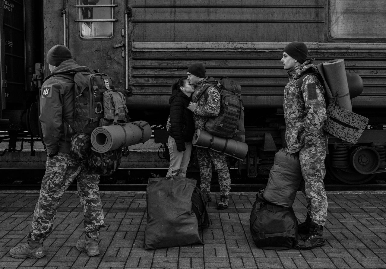 A Ukrainian soldier embraces his girlfriend while waiting to board a train heading for the frontlines at Lviv-Holovnyi railway station.