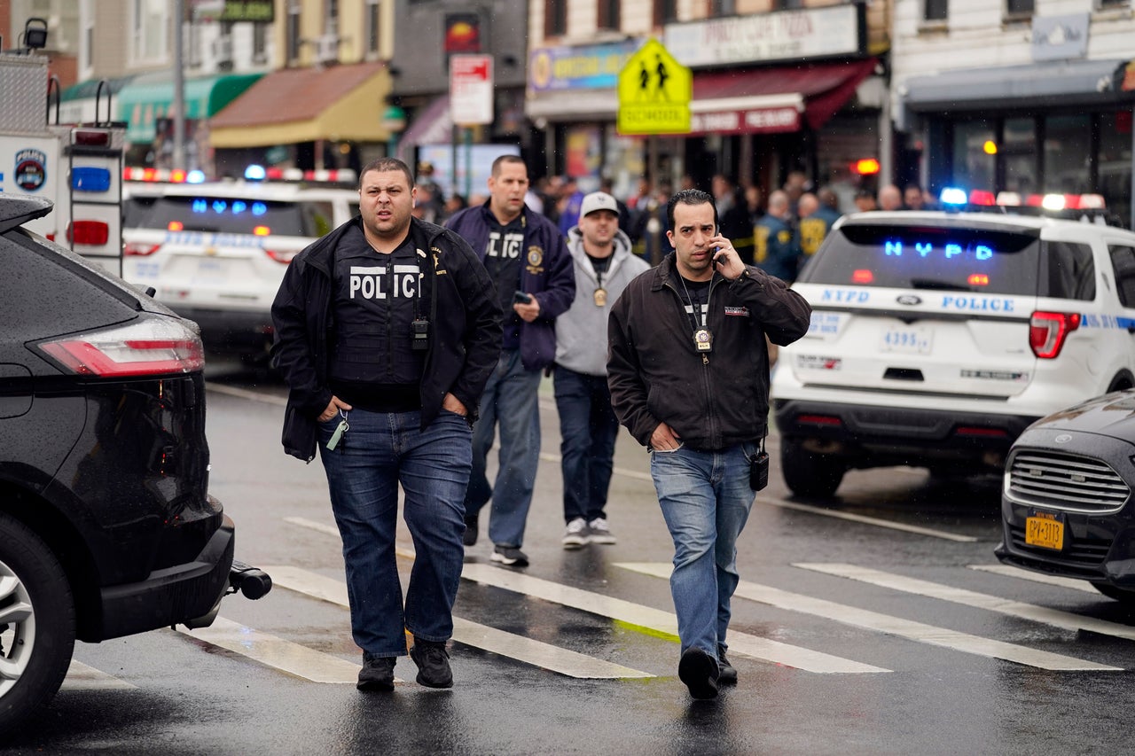 New York City Police Department personnel gather at the entrance of the subway stop. 