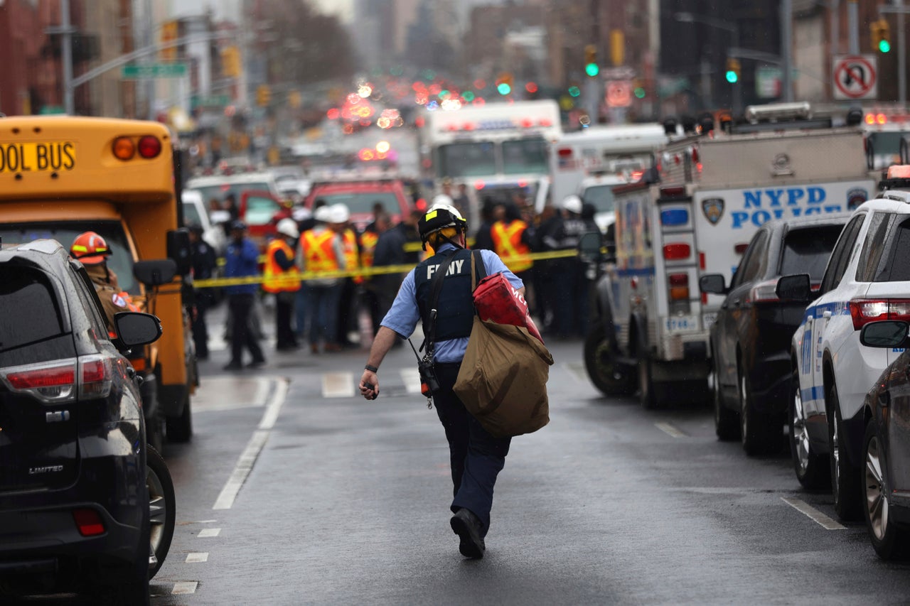 Law enforcement gather near the entrance to the subway stop. 