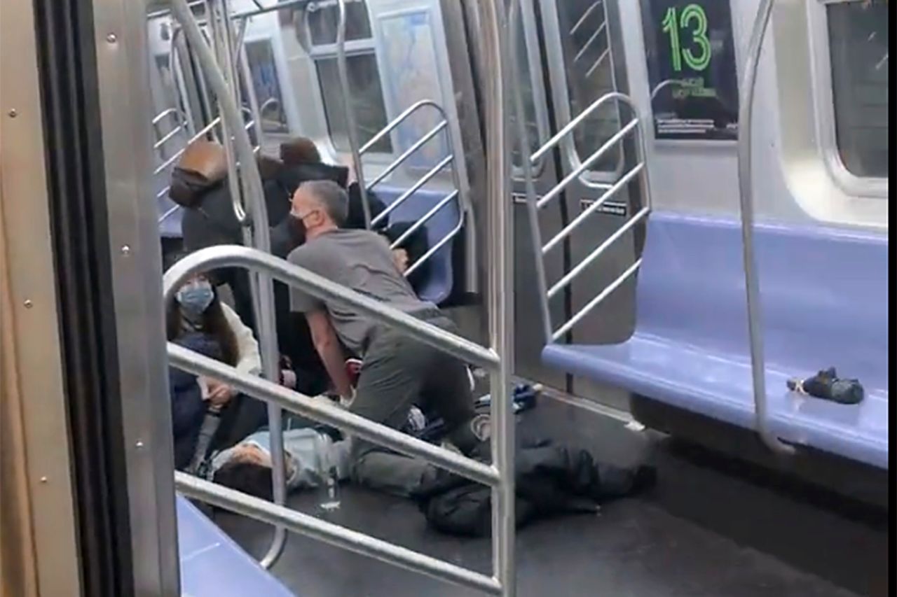A person is aided in a subway car. 