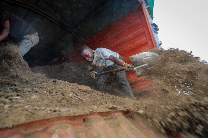 Farmers offload livestock manure from a truck, that will be used to fertilize crops, in Kiambu, near Nairobi, in Kenya, on March 31, 2022.