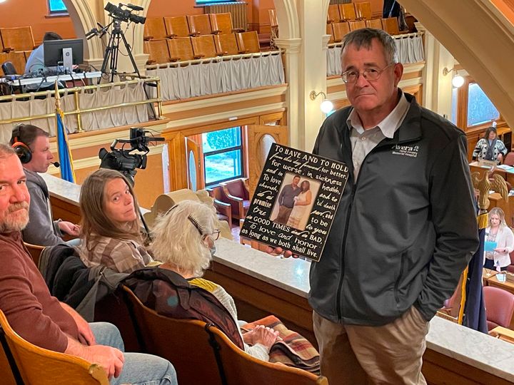 Nick Nemec, the cousin of Joseph Boever, poses with a wedding photo of Boever in the South Dakota House gallery before lawmakers voted to impeach Attorney General Jason Ravnsborg on Tuesday in Pierre, S.D.