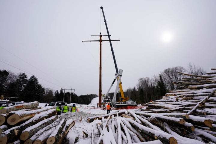 Workers connect a section of the first pole of Central Maine Power's controversial hydropower transmission corridor, Feb. 9, 2021, near The Forks, Maine. Mainers ultimately voted in a referendum last November to block further construction of the line.