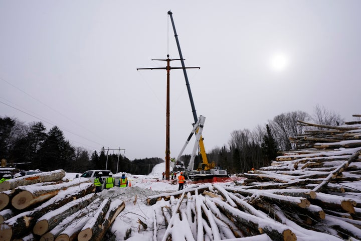 Workers connect a section of the first pole of Central Maine Power's controversial hydropower transmission corridor, Feb. 9, 2021, near The Forks, Maine. Mainers ultimately voted in a referendum last November to block further construction of the line. 