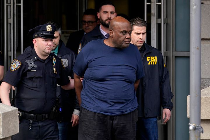 Subway shooting suspect Frank R. James, 62, center, is seen being led by police from a police station in New York on Wednesday.