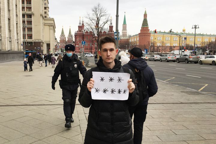 Αστυνομικοί, αριστερά, ετοιμάζονται να συλλάβουν τον Ντμίτρι Ρέζνικοφ που κρατάει ένα λευκό κομμάτι χαρτί με οκτώ αστερίσκους που θα μπορούσαν να ερμηνευθούν ως «Όχι στον πόλεμο» στα ρωσικά. Το δικαστήριο τον έκρινε ένοχο για δυσφήμιση των ενόπλων δυνάμεων και του επέβαλε πρόστιμο 50.000 ρούβλια (618 $) επειδή κράτησε την πινακίδα σε μια διαδήλωση που διήρκεσε μόνο δευτερόλεπτα πριν τον συλλάβει η αστυνομία.