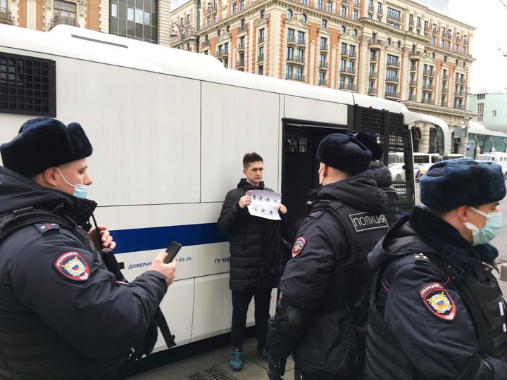 Ο Ντμίτρι Ρέζνικοφ κρατώντας ένα λευκό κομμάτι χαρτί με οκτώ αστερίσκους που θα μπορούσαν να ερμηνευθούν ως «Όχι στον πόλεμο» στα ρωσικά, στέκεται δίπλα σε ένα βαν της αστυνομίας καθώς κρατούνταν στη Μόσχα. Το δικαστήριο τον έκρινε ένοχο για δυσφήμιση των ενόπλων δυνάμεων και του επέβαλε πρόστιμο 50.000 ρούβλια (618 δολάρια) επειδή κράτησε την πινακίδα στο κέντρο της Μόσχας σε μια διαδήλωση στα μέσα Μαρτίου που κράτησε μόνο δευτερόλεπτα πριν τον συλλάβει η αστυνομία. 