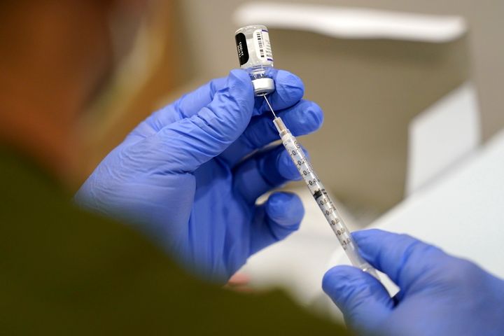 A healthcare worker fills a syringe with the Pfizer COVID-19 vaccine at Jackson Memorial Hospital in Miami.
