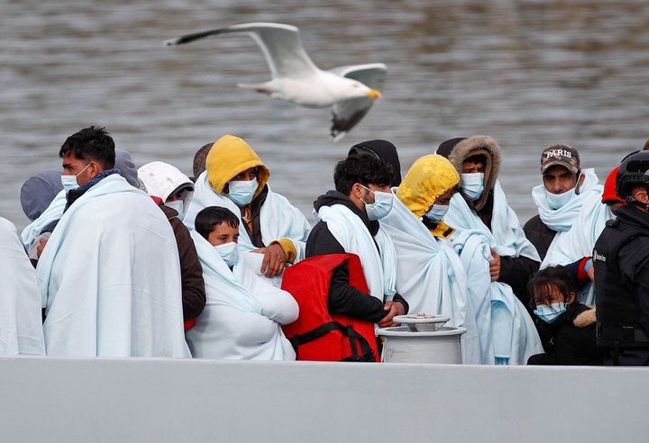 Ένα πουλί περνά μπροστά από μετανάστες που περιμένουν να αποβιβαστούν στο λιμάνι του Ντόβερ αφού διασώθηκαν ενώ διέσχιζαν τη Μάγχη, στο Ντόβερ της Βρετανίας, 14 Απριλίου 2022. REUTERS/Peter Nicholls