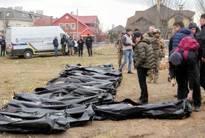 Ukrainian Prosecutor General Iryna Venediktova, center, looks at the exhumed bodies of civilians killed during the Russian occupation in Bucha, on the outskirts of Kyiv, Ukraine. 