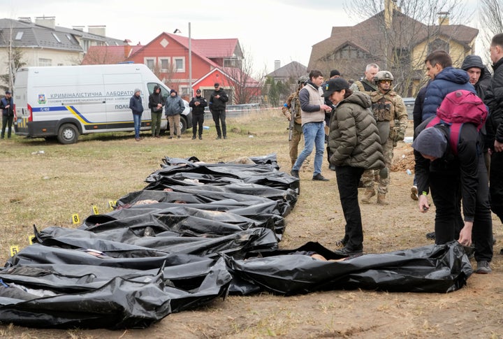 Ukrainian Prosecutor General Iryna Venediktova, center, looks at the exhumed bodies of civilians killed during the Russian occupation in Bucha, on the outskirts of Kyiv, Ukraine. 