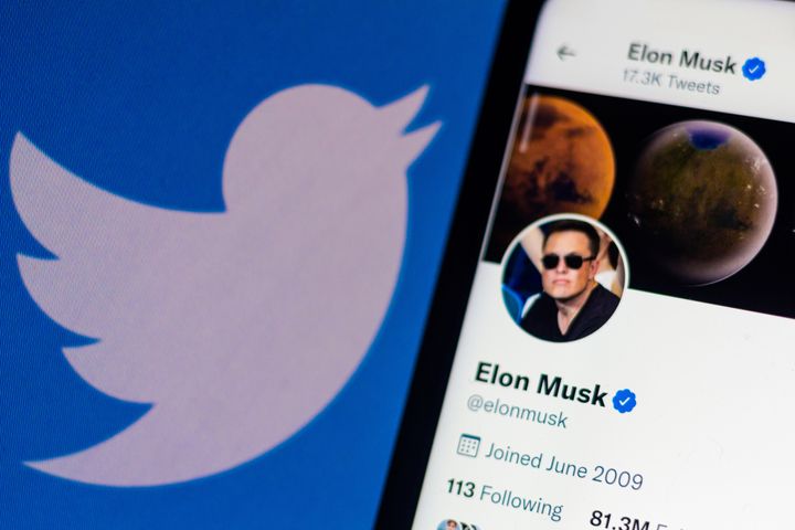 Un móvil con el perfil de Elon Musk en Twitter, con el logo de la compañía de fondo.