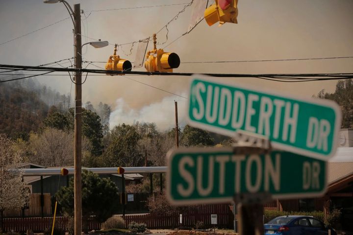 Smoke from the McBride Fire rises near an intersection in Ruidoso, New Mexico, on Wednesday, April 13, 2022.