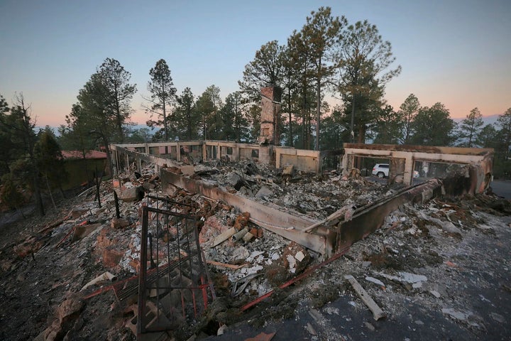 A two-story house continues to smolder following the McBride Fire in Ruidoso, New Mexico, on Thursday, April 14, 2022.