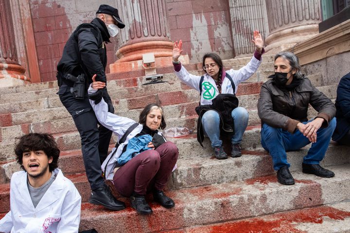 Police grab climate protesters from the steps of a government building in Madrid on April 6.