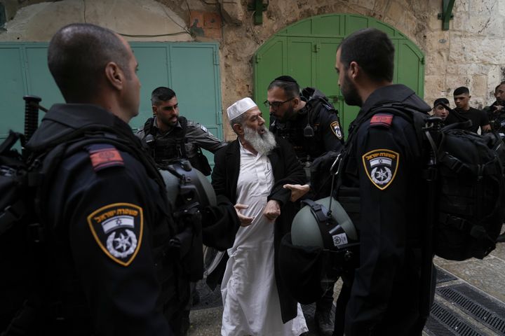 Israel police argues with a Palestinian worshipers the Old City of Jerusalem, Sunday, April 17, 2022. Israeli police clashed with Palestinians outside Al-Aqsa Mosque after police violently cleared Palestinians from the sprawling compound to facilitate the routine visit of Jews to the holy site and accused Palestinians of stockpiling stones in anticipation of violence. 