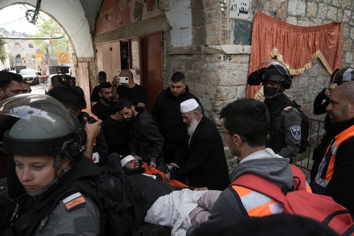 Paramedics carry a Palestinian injured by Israeli police in the Old City of Jerusalem, Sunday, April 17, 2022. 