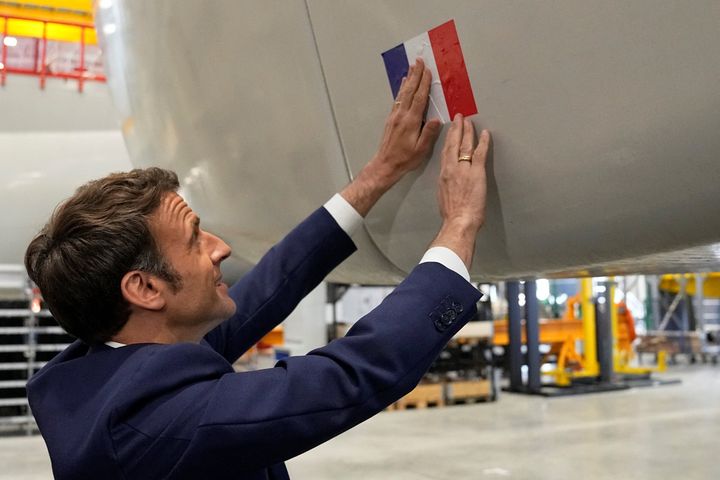 Ο Γάλλος πρόεδρος και υποψήφιος για επανεκλογή του Εμμανουέλ Μακρόν κολλάει μια γαλλική σημαία σε μια πλατφόρμα ανεμογεννήτριας στο εργοστάσιο ανεμογεννητριών Siemens Gamesa κατά τη διάρκεια επίσκεψης του στο πλαίσιο της εκστρατείας του στη Χάβρη, στις 14 Απριλίου 2022.