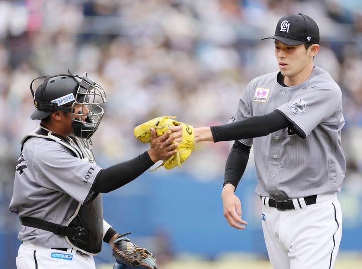 捕手の松川虎生選手（左）とタッチを交わす佐々木朗希投手（右）