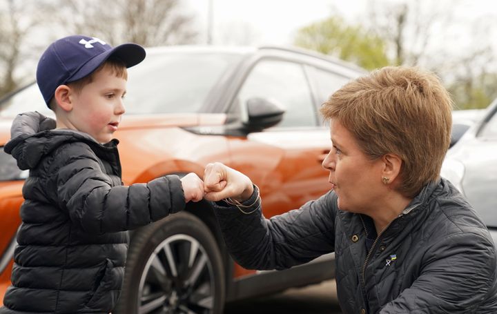 First Minister Nicola Sturgeon fist pumps Addison Mitchell, four, in Perth during local election campaigning. Picture date: Friday April 15, 2022.