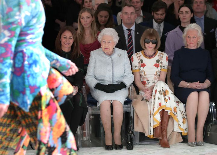 Queen Elizabeth sits beside Anna Wintour (second from right) and royal dressmaker Angela Kelly (far right) as they view British designer Richard Quinn's runway on Feb. 20, 2018.