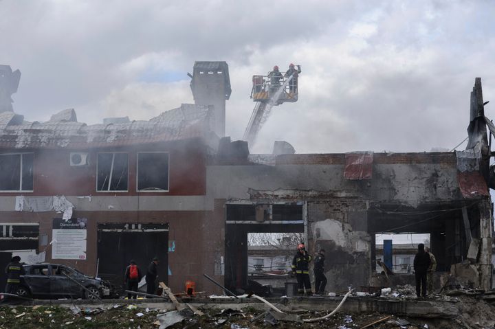 Firefighters work to extinguish a fire after an airstrike hit a tire shop in Lviv, Ukraine, on April 18, 2022.