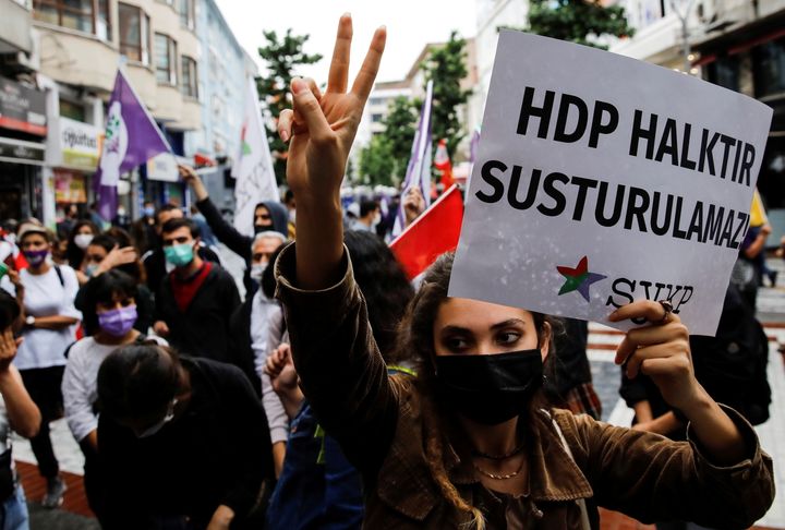 Διαδηλώτρια κάνει το σύμβολο της νίκης και κρατά ένα πανό που γράφει " Το HDP είναι άνθρωποι, δεν μπορούν να φιμωθούν" κατά τη διάρκεια μιας διαδήλωσης αλληλεγγύης για το φιλοκουρδικό Δημοκρατικό Κόμμα των Λαών στην Κωνσταντινούπολη, Τουρκία, 18 Ιουνίου 2021