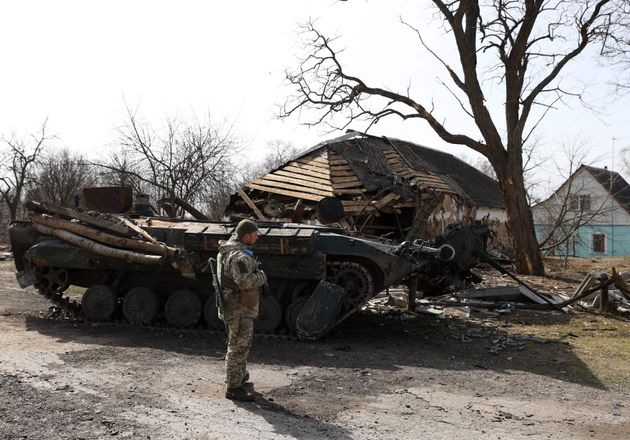 2022年03月28日＝破壊されたロシア軍の車両の前に立つウクライナの兵士（ウクライナ・キエフ郊外）