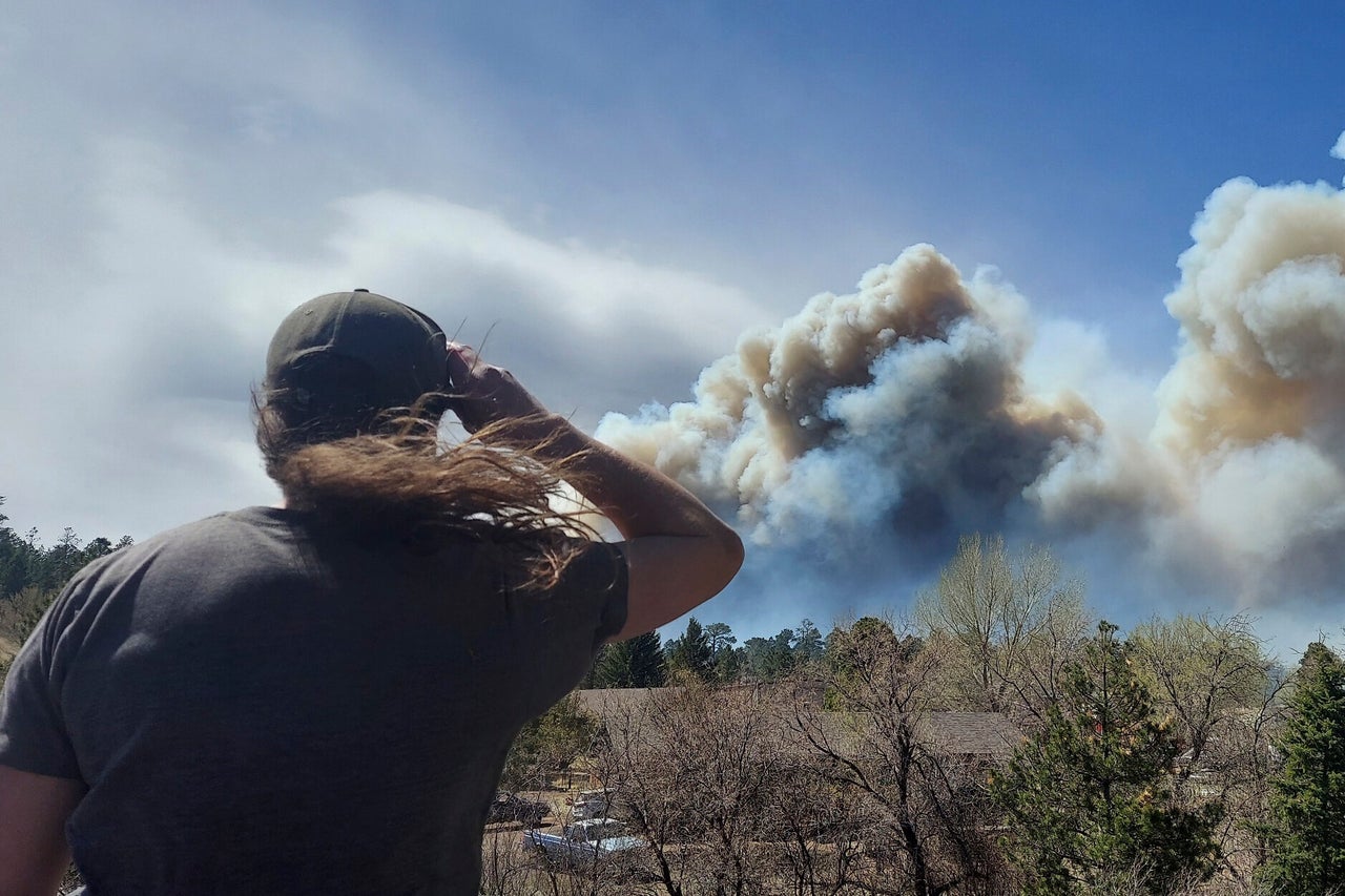 Smoke from a wind-whipped wildfire rises above neighborhoods on the outskirts of Flagstaff, Arizona, on April 19, 2022.