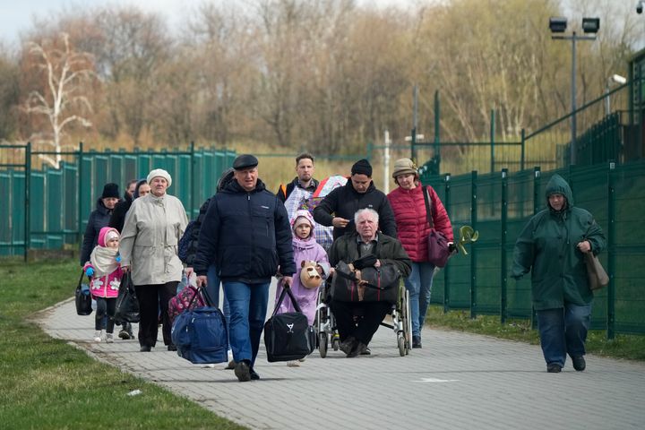 Refugees walk after fleeing the war from neighboring Ukraine at the border crossing in Medyka, southeastern Poland.