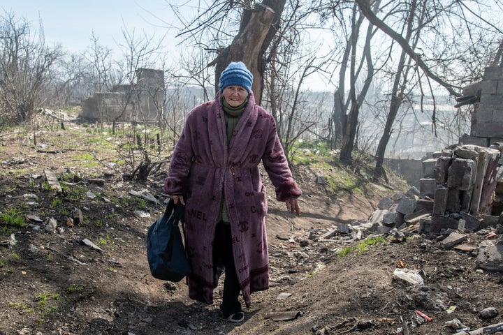 Une femme marche sur une colline menant à la mer d'Azov dans la zone sud de Marioupol.  La bataille entre les forces russes / pro-russes et les forces ukrainiennes en défense dirigées par le bataillon Azov se poursuit dans la ville portuaire de Marioupol.