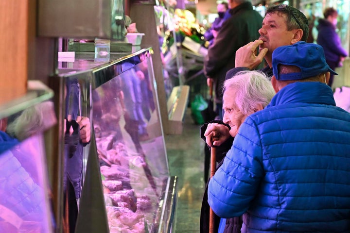 Un par de clientes sin mascarilla aguardan a ser atendidos un mercado de Madrid, este miércoles.