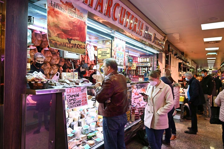 Un par de clientes con y sin mascarilla visitan un mercado de Madrid.
