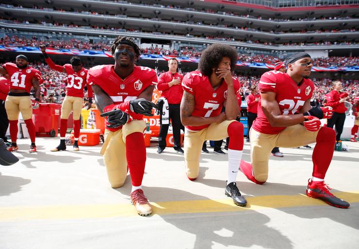 Antoine Bethea (41) and Rashard Robinson (33) of the San Francisco 49ers raise their fists during the national anthem while Eli Harold (58), Colin Kaepernick (7) and Eric Reid (35) take a knee on Oct. 2, 2016.