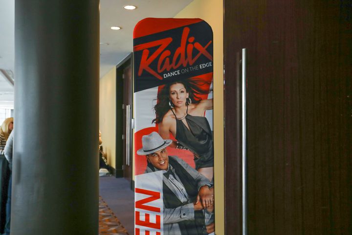 A sign points attendees to a RADIX competition room in Rosemont, Ill., on Feb. 4, 2022. Break The Floor hosts conventions in cities across North America, putting on events in hotel ballrooms every weekend over the course of a six-month season. Hundreds of studios and schools from smaller communities bring teams of dancers to the events, branded as JUMP, NUVO, 24seven, RADIX and DancerPalooza.