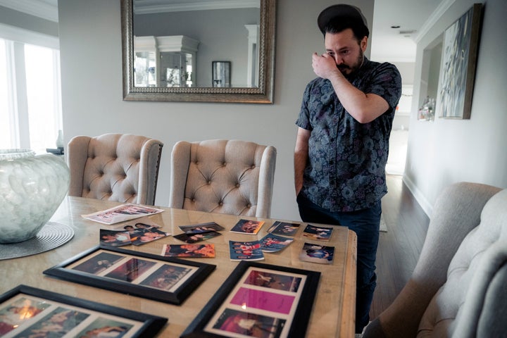 Gary Schaufeld wipes a tear from his eyes as he shows pictures from his youth of him performing in dance competitions, Thursday, Feb. 10, 2022, at his home in Port Jefferson, N.Y. Schaufeld stopped dancing years ago and has no plans to return to the studio. “It was my church,” he said, but now “the whole dance scene feels dirty and tainted.”