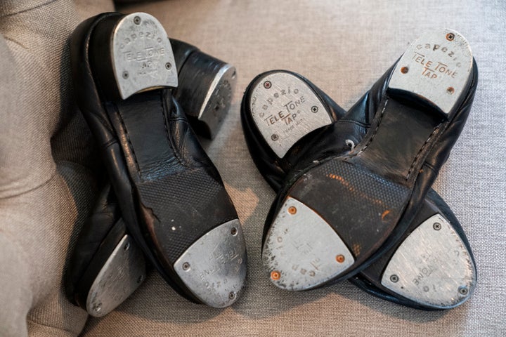 Old tap shoes rest on a chair as Gary Schaufeld describes his time as a young performer in dance competitions, Thursday, Feb. 10, 2022, at his home in Port Jefferson, N.Y. He was a teen in 2004, assisting a successful tap dancer named Danny Wallace. Schaufeld had fallen in love with tap at 7 years old, and assisting Wallace offered a chance to raise his profile and learn from one of the best.