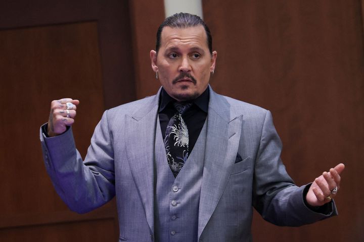 Actor Johnny Depp demonstrates what he claims was an alleged attack by his ex-wife Amber Heard as he testifies during his defamation trial against Heard, at the Fairfax County Circuit Courthouse in Fairfax, Virginia, April 20, 2022. - Depp is suing ex-wife Heard for libel after she wrote an op-ed piece in The Washington Post in 2018 referring to herself as a public figure representing domestic abuse.