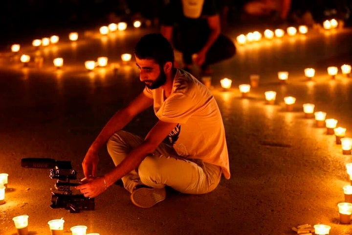 This photo provided by the family of Mohammed Nour Matar, shows Syrian journalist Mohammed Nour Matar filming during a vigil, in Raqqa, Syria, March 2013. Matar is among thousands of people believed to have been seized by the Islamic State. Three years after the territorial defeat of the IS, thousands of people seized by the extremist group are still missing, and accountability for their captors remains elusive.
