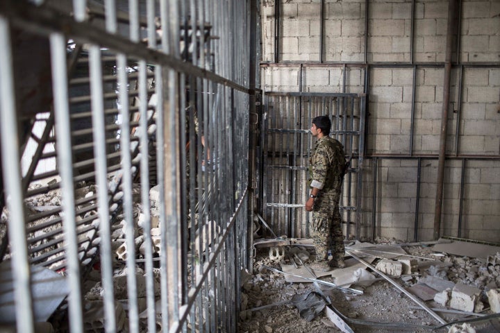 Members of the U.S.-backed Syrian Democratic Forces walk inside a prison built by Islamic State fighters at the stadium that was the site of Islamic State fighters' last stand in the city of Raqqa, Syria, Oct. 20, 2017. 