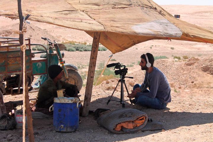 This photo provided by the family of Mohammed-Nour Mattar, shows Syrian journalist Mohammed Nour Matar interviewing a man while filming a documentary about primitive ways of refining oil, in the Raqqa countryside of Syria, August 2013. 