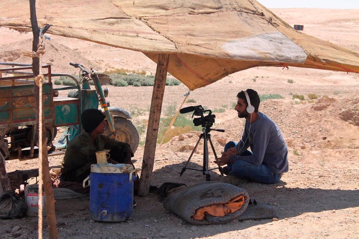 This photo provided by the family of Mohammed-Nour Mattar, shows Syrian journalist Mohammed Nour Matar interviewing a man while filming a documentary about primitive ways of refining oil, in the Raqqa countryside of Syria, August 2013.