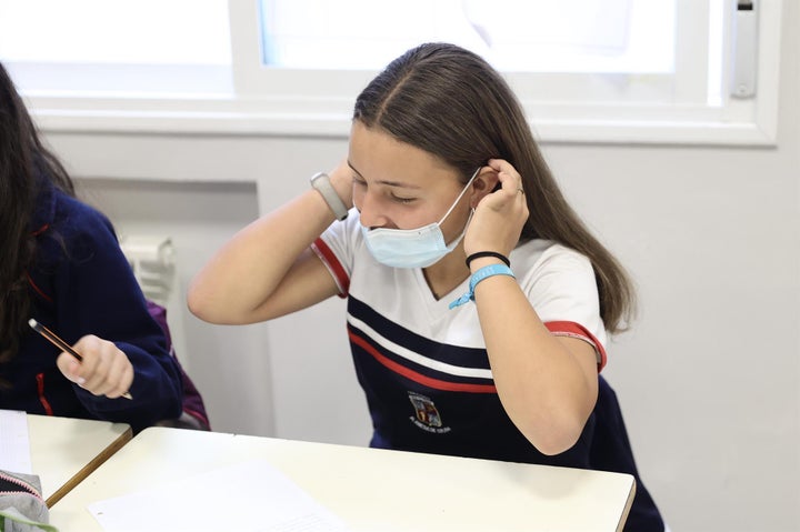 Una niña se quita la mascarilla durante una clase, el día en que ha entrado en vigor el decreto que pone fin al uso de la mascarilla en la mayoría de interiores, en el Colegio Alameda de Osuna, en Madrid.
