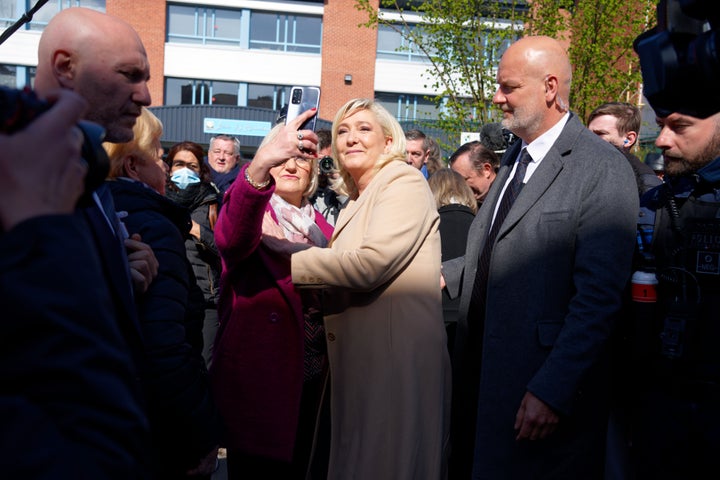 Le Pen se hace selfies después de votar en la primera vuelta de las elecciones.