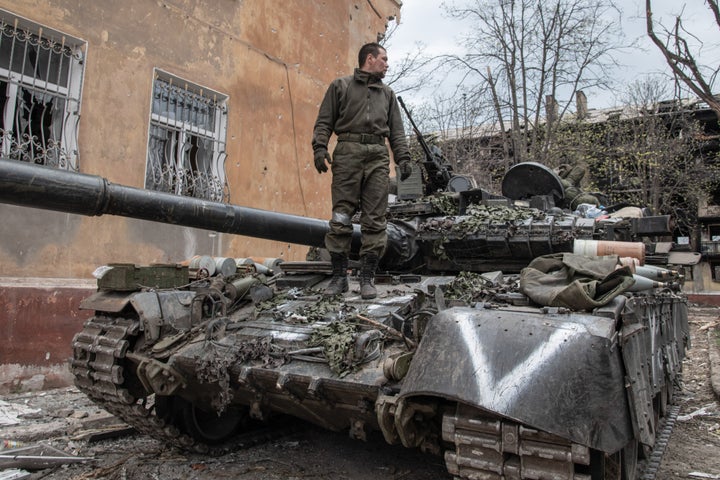 Un soldado ruso posa sobre uno de los tanques de Moscú 'decorados' con el símbolo nacional de la 'V'