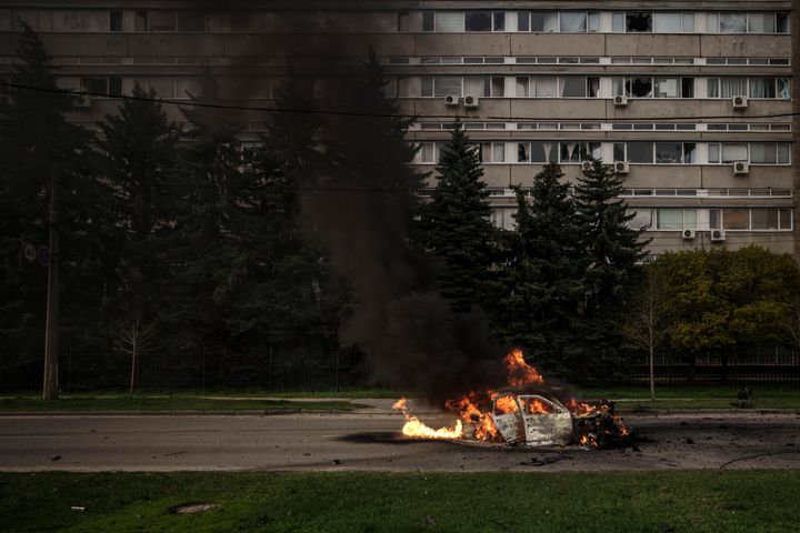 A car burns with two people inside, after a Russian bombardment in Kharkiv, Ukraine, Thursday, April 21, 2022. (AP Photo/Felipe Dana)