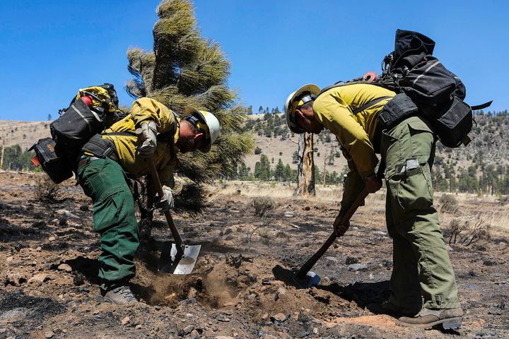 Two firefighters monitor hot spots from a wildfire burning on the outskirts of Flagstaff, Ariz., Thursday, April 21, 2022. (Rachel Gibbons/Arizona Daily Sun via AP)